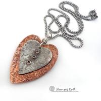 This mixed metal heart necklace has an earthy, rustic charm and will make a great gift for someone special. It features nesting hearts handcrafted from sterling silver and copper. It comes on a 20" stainless steel chain with lobster claw closure. The necklace holds a special significance as it represents two hearts coming together in union. This could be a meaningful gift for someone you love deeply.  The perfect gift for a wife, mom or girlfriend. Makes a great gift for couples celebrating their 7th weddin