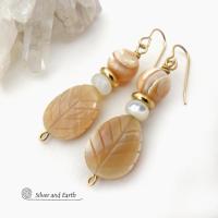 These handcrafted earrings feature golden Mother-of-Pearl carved leaf beads accented with small Mother-of-Pearl beads, shiny gold brass beads and topped off with round golden Mother-of-Pearl beads. The Mother-of-Pearl has a natural shimmery hue which casts off a beautiful shine. They have an elegant, modern style that will look great dressed up or down. They'll make a great gift for a nature lover. Handmade in the USA by Silver and Earth Jewelry.