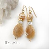 These handcrafted earrings feature golden Mother-of-Pearl carved leaf beads accented with small Mother-of-Pearl beads, shiny gold brass beads and topped off with round golden Mother-of-Pearl beads. The Mother-of-Pearl has a natural shimmery hue which casts off a beautiful shine. They have an elegant, modern style that will look great dressed up or down. They'll make a great gift for a nature lover. Handmade in the USA by Silver and Earth Jewelry.