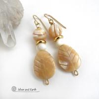 These handcrafted earrings feature golden Mother-of-Pearl carved leaf beads accented with small Mother-of-Pearl beads, shiny gold brass beads and topped off with round golden Mother-of-Pearl beads. The Mother-of-Pearl has a natural shimmery hue which casts off a beautiful shine. They have an elegant, modern style that will look great dressed up or down. They'll make a great gift for a nature lover. Handmade in the USA by Silver and Earth Jewelry.