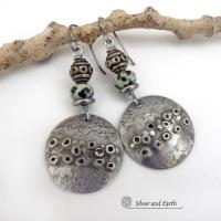 These handcrafted silver pewter earrings have a rustic, hand textured design and are accented with natural dalmatian jasper gemstones, stainless steel and vintage silver tone metal beads. They have an earthy, edgy organic style that makes a unique statement.This type of jasper is known for its spotted pattern that resembles the Dalmatian breed of dog. The matrix consists of mineral inclusions of brown iron oxide, black tourmaline & other minerals which create the natural "spots" in the stone. Handmade in th
