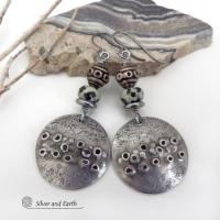 These handcrafted silver pewter earrings have a rustic, hand textured design and are accented with natural dalmatian jasper gemstones, stainless steel and vintage silver tone metal beads. They have an earthy, edgy organic style that makes a unique statement.This type of jasper is known for its spotted pattern that resembles the Dalmatian breed of dog. The matrix consists of mineral inclusions of brown iron oxide, black tourmaline & other minerals which create the natural "spots" in the stone. Handmade in th