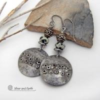 These handcrafted silver pewter earrings have a rustic, hand textured design and are accented with natural dalmatian jasper gemstones, stainless steel and vintage silver tone metal beads. They have an earthy, edgy organic style that makes a unique statement.This type of jasper is known for its spotted pattern that resembles the Dalmatian breed of dog. The matrix consists of mineral inclusions of brown iron oxide, black tourmaline & other minerals which create the natural "spots" in the stone. Handmade in th