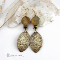 These handcrafted earrings feature textured gold brass dangles accented with natural Picasso jasper gemstones and hematite stone beads. The beads have an electroplated champagne gold tone finish which adds a touch of shimmer and shine. They have an earthy modern style that coordinates well with all wardrobe styles. Coordinating necklace is available and sold separately.