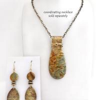These handcrafted earrings feature textured gold brass dangles accented with natural Picasso jasper gemstones and hematite stone beads. The beads have an electroplated champagne gold tone finish which adds a touch of shimmer and shine. They have an earthy modern style that coordinates well with all wardrobe styles. Coordinating necklace is available and sold separately.