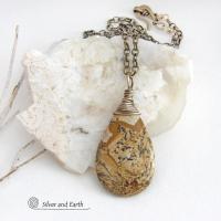 This one-of-a-kind necklace features a natural picture jasper stone wrapped in gold brass wire. The stone has an interesting matrix pattern with earthy hues of brown, tan and black. It has an earthy, simple style that coordinates beautifully with all wardrobe styles. It makes a great gift for a natural stone lover - or a nice addition to your own jewelry collection. Handmade in the USA by Silver and Earth Jewelry. Coordinating earrings sold separately.