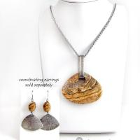 This handcrafted necklace features a large, chunky natural picture jasper stone accented with a handcrafted sterling silver bail. The stone has a beautiful natural pattern in various shades of brown, beige and gray. Big and bold, this necklace is a real one-of-a-kind statement piece - perfect for anyone that loves natural stones! It's reversible and can be worn on either side. Coordinating earrings sold separately. Handmade in the USA by Silver and Earth Jewelry.