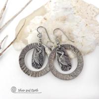 These handcrafted earrings feature silver pewter circle hoops with a hammered texture accented with silver pewter bird charms dangling in front. Lightweight and comfortable to wear, they have a casual earthy style with rustic flair that coordinates with all wardrobe types. They'll make a great gift for a nature / bird lover - or a unique addition to your own jewelry wardrobe. Handmade in the USA by Silver and Earth Jewelry.