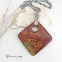 This artisan handcrafted one-of-a-kind necklace features a natural red creek jasper stone accented with a hand forged sterling silver bail with a lightly hammered texture. The stone has a beautiful natural pattern in earthy hues of mossy greens, brick red, brown and orange. It's reversible and can be worn on either side. (See all photos for alternate sides). It makes a great gift for anyone that loves earthy colors and natural stones. The design is unisex so it could be worn by a man or woman.