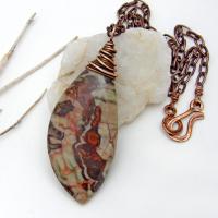 This necklace features a natural rhyolite jasper stone with a natural pattern in earthy hues of rusty orange, brown and taupe. It is wrapped in oxidized copper wire and comes on an 18" copper chain necklace. It has an earthy, natural style and will make a great gift for a natural stone lover - or a nice addition to your own jewelry collection. The chain can be removed from the pendant and worn with other pendants in your wardrobe. Coordinating earrings sold separately. 