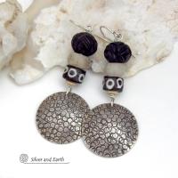 These handcrafted sterling silver earrings have an ethnic, tribal vibe. They feature African carved bone, glass and batik bone beads accented with hand stamped sterling silver dangles. Bold and striking, they'll make an exotic statement. Perfect for women that love to wear unique jewelry. Handmade in the USA by Silver and Earth Jewelry. 