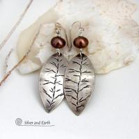These handcrafted sterling silver leaf earrings have a delicate hand stamped texture and are accented with bronze freshwater pearls. They have a modern, earthy elegance that coordinates beautifully with all wardrobe styles. They'll make a great gift for a nature lover. Handcrafted exclusively in the USA by Silver and Earth Jewelry, a New Mexico True Certified business.
