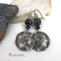 Handcrafted earrings with a modern bold edgy vibe. They feature rustic hammered and hand stamped silver tone pewter dangles accented with natural snowflake obsidian gemstones. The stones have a natural pattern in hues of black and soft gray. This stone is a natural volcanic glass which contains the mineral cristobalite - which creates the "snowflake" type patterns. Bold and striking - they're sure to make a statement. Earrings l