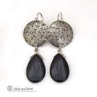 These handcrafted sterling silver earrings have a hand stamped texture and feature dangling black onyx teardrop-shaped gemstones. They have a contemporary modern style with a bold urban chic flair that coordinates beautifully with all wardrobe types.