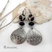 These handcrafted silver pewter earrings have a rustic, hammered texture and are accented with black and off-white Tibetan agate faceted gemstones, black glass and stainless steel beads. Bold and striking, they'll make a unique ethnic tribal statement. Perfect for women that love to wear unique, eye-catching jewelry. Handmade in the USA by Silver and Earth Jewelry.  MEASUREMENTS: Total length of approximately 2-1/2" from top of silver niobium (hypoallergenic) ear wires and 1” at widest point.