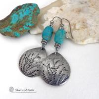 These handcrafted earrings feature silver pewter teardrop-shaped dangles with a hand stamped feather texture accented with natural turquoise stones and small stainless steel beads. They have a modern earthy style with boho chic southwestern flair. They'll make a great gift for anyone that loves natural turquoise stones and southwest style jewelry. Handmade in the USA by Silver and Earth jewelry, a NM True Certfied Business. 
