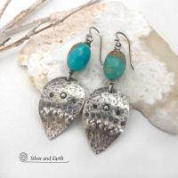 These handcrafted earrings feature natural turquoise nuggets accented with sterling silver dangles with a hammered and hand stamped texture. The stones are a gorgeous shade of turquoise with a natural copper matrix. They have an earthy organic, modern style with southwestern flair. The earrings are handmade and are a beautiful example of southwest style jewelry. Handmade by Silver and Earth, a New Mexico True Certified business.