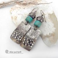 Artisan handcrafted earrings featuring sterling silver rectangles with a hammered and hand stamped texture accented with natural turquoise stones and topped off with oxidized and stamped Native American made sterling silver beads. They have a modern, southwest tribal style and will make a bold statement. Perfect for anyone that loves southwest style jewelry. Handmade in New Mexico by Silver and Earth, a New Mexico Certified True company. 