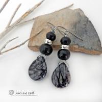 The earrings feature natural zebra jasper stones accented with black beads and silver plated beads and dangle from hypoallergenic titanium ear wires. This stone is known as zebra jasper because of the natural striped matrix that resembles a zebra's pattern. It's a striking stone with earthy hues of soft gray, along with streaks of black. They'll make a great gift for a natural stone lover - or a nice addition to your own jewelry wardrobe. Handmade in the USA by Silver and Earth Jewelry. 