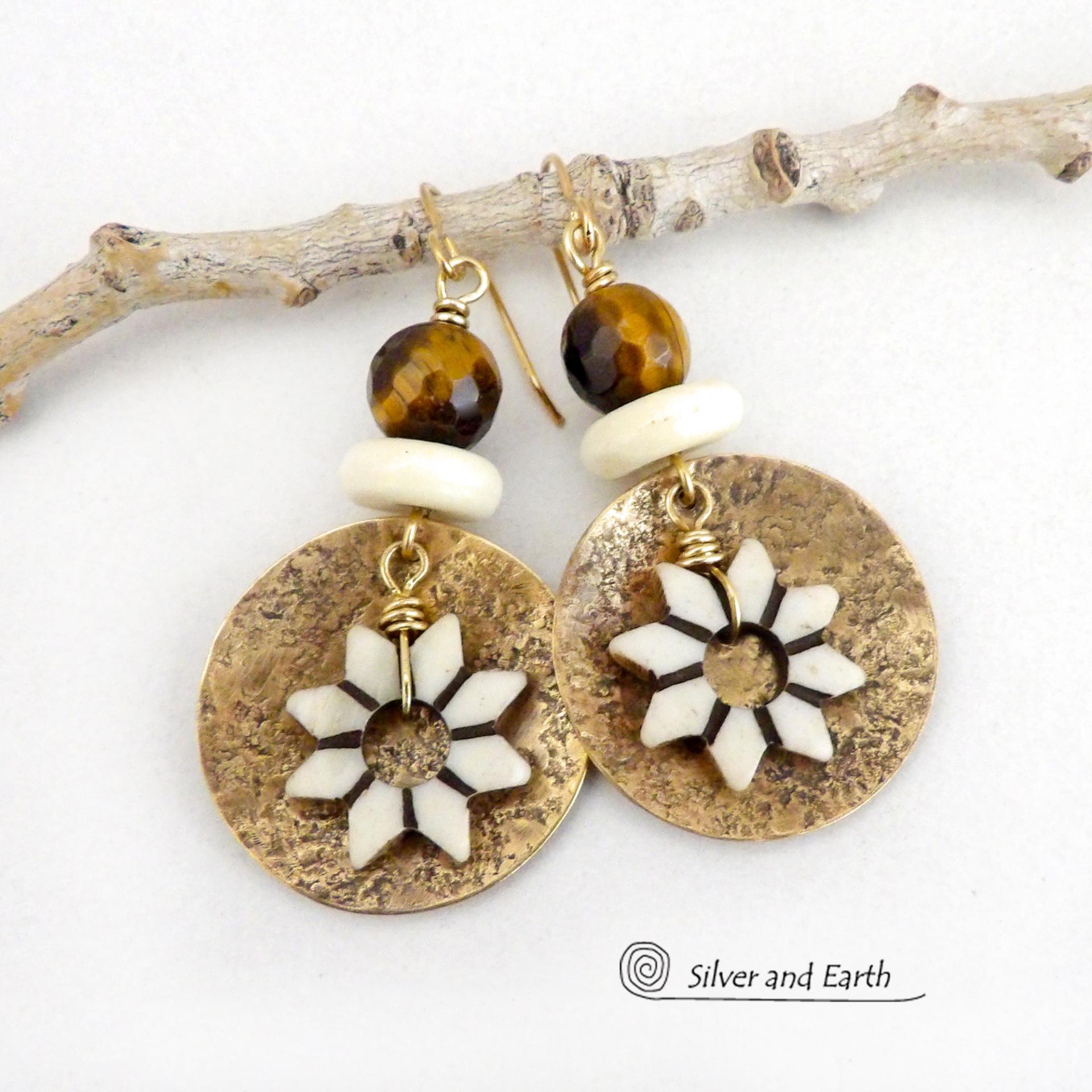These handmade gold brass earrings have an ethnic bohemian style with an African inspired flair that makes a bold statement. They feature round brass dangles with a lightly hammered texture accented with African flower-shaped bone beads, faceted natural tiger's eye gemstones and African bone beads. Unique and fun to wear, they'll make a great gift for nature lovers and gardeners who love bohemian style jewelry.