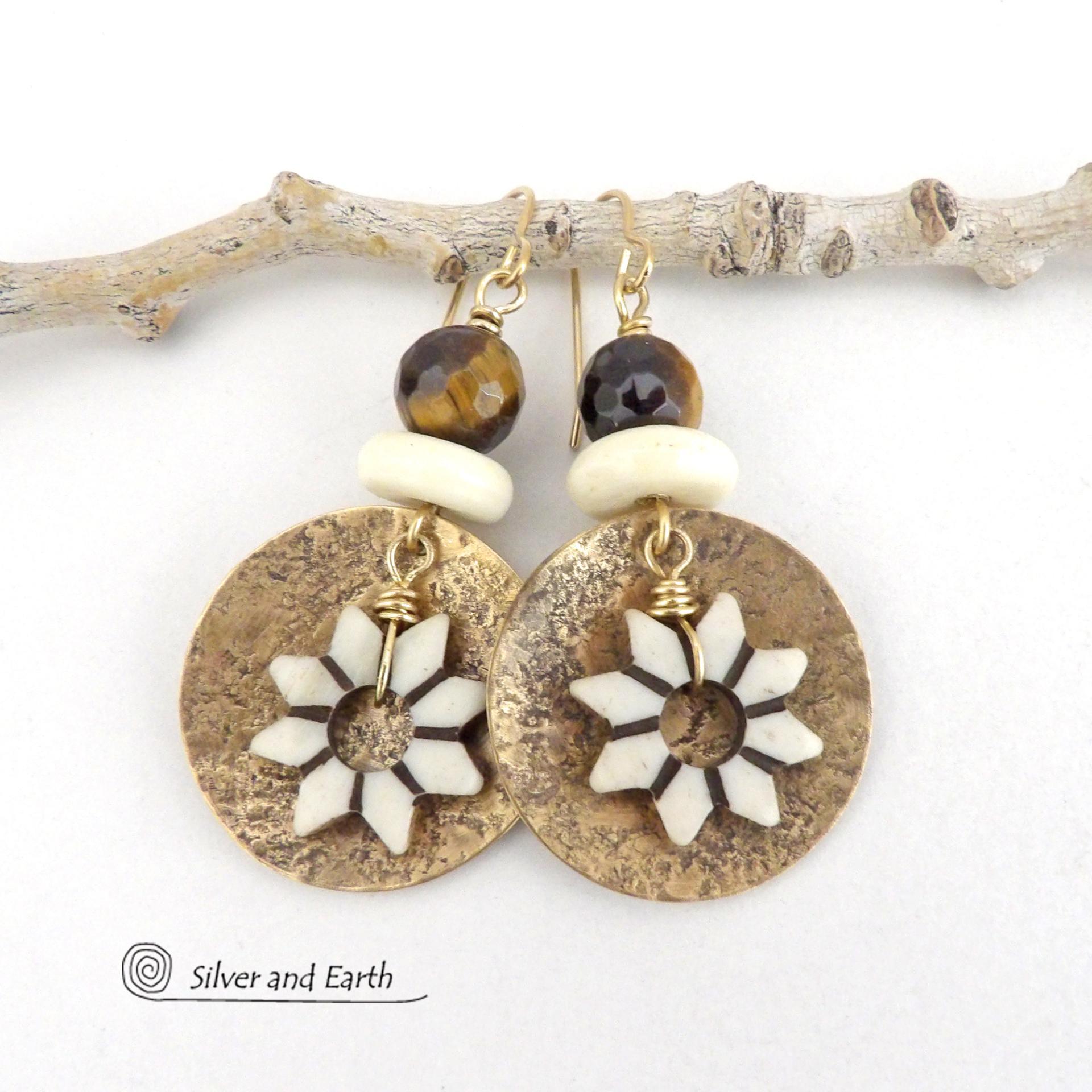 These handmade gold brass earrings have an ethnic bohemian style with an African inspired flair that makes a bold statement. They feature round brass dangles with a lightly hammered texture accented with African flower-shaped bone beads, faceted natural tiger's eye gemstones and African bone beads. Unique and fun to wear, they'll make a great gift for nature lovers and gardeners who love bohemian style jewelry.