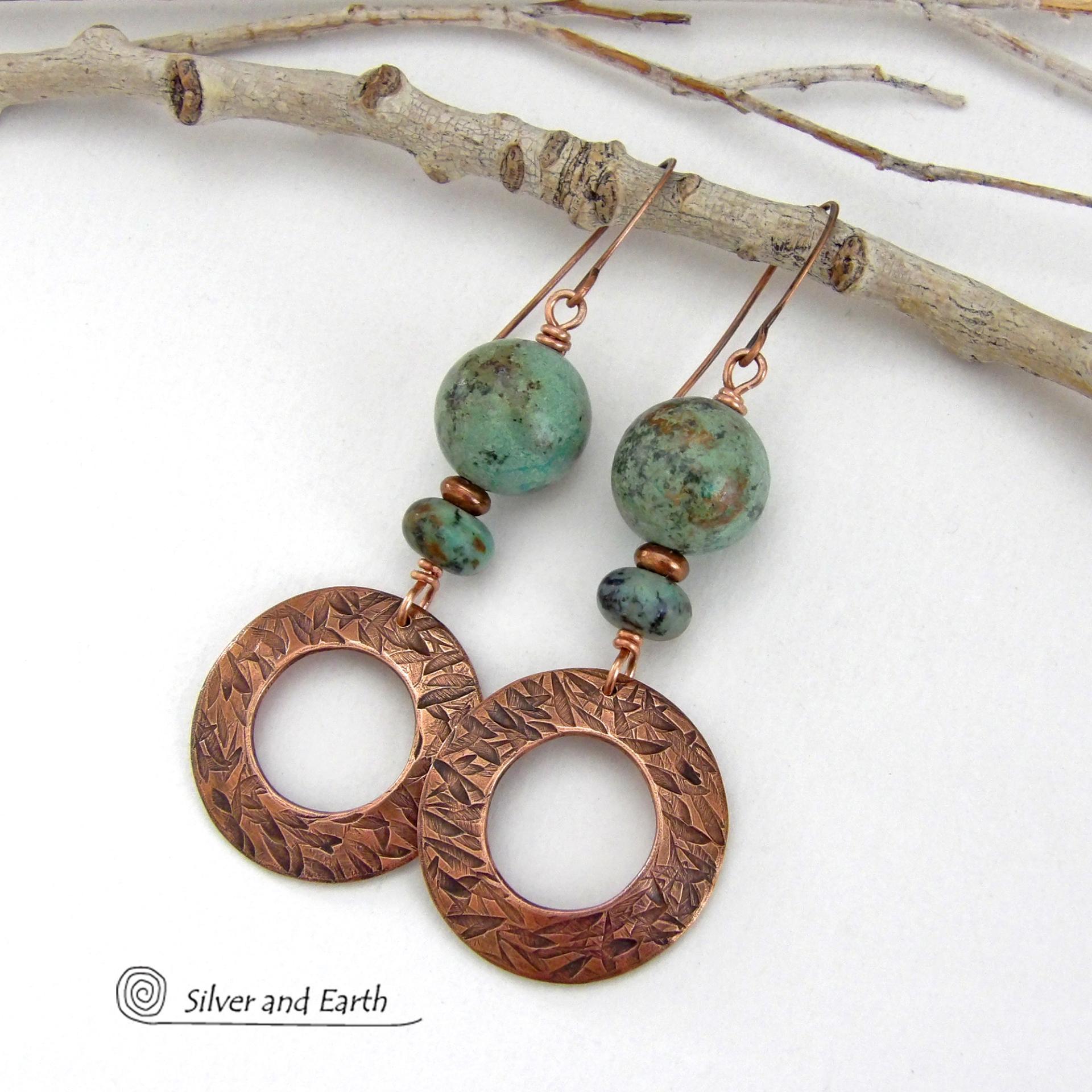  These handcrafted earrings feature round copper hoop dangles with a hand stamped texture accented with a stack of natural African turquoise stones and tiny copper beads. The stones have a pretty turquoise hue with an earthy natural black and brown matrix. These earrings have an earthy chic style with a modern bohemian flair that will coordinate beautifully with all wardrobe types. Handmade in the USA by Silver and Earth Jewelry.  Your choice of ear wires - copper or hypoallergenic niobium. 