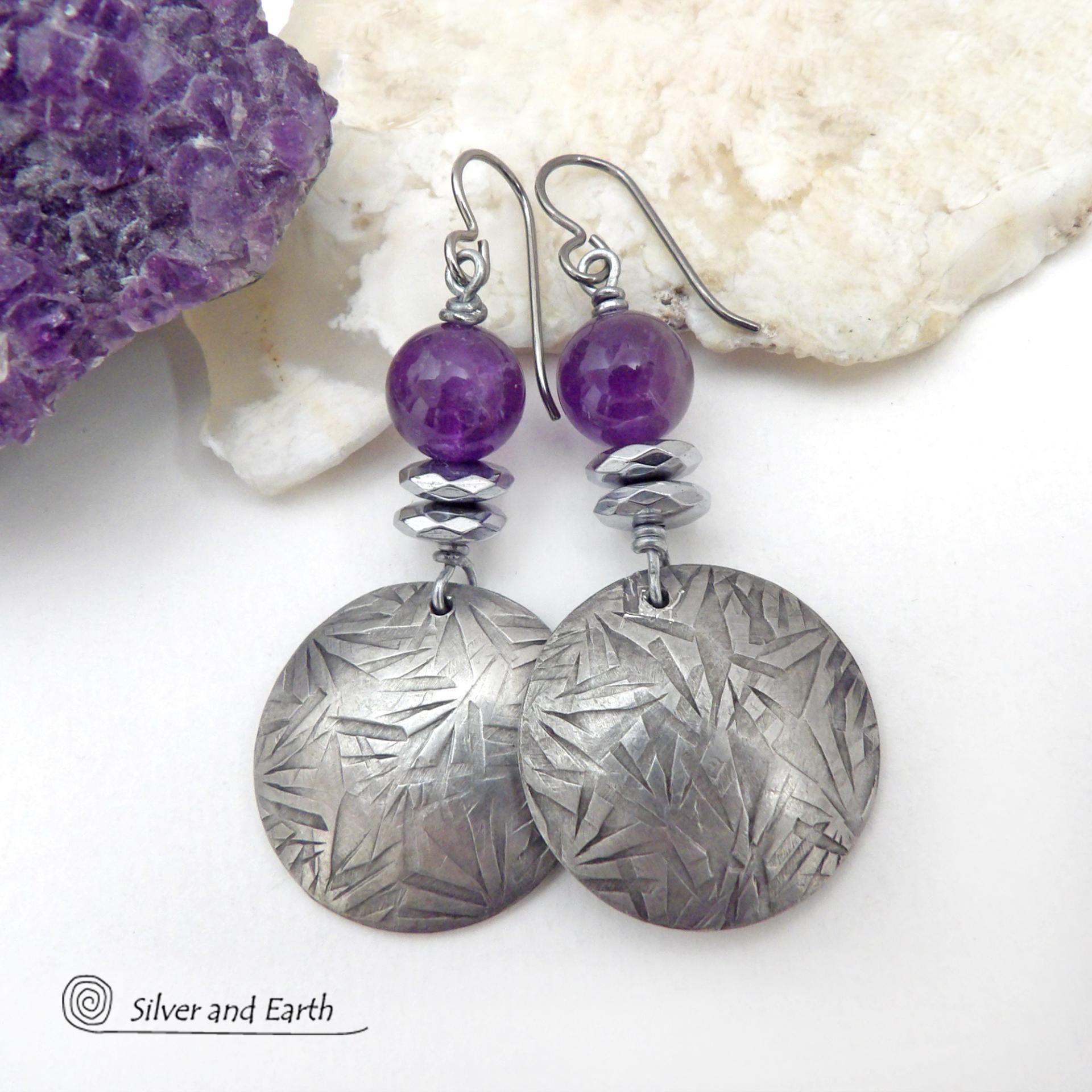 These handcrafted round silver pewter earrings have a hand stamped texture and are accented with purple amethyst and faceted hematite gemstones. The hematite has a natural sparkle and shine which gives these earrings an elegant, modern chic style that will look great dressed up or down. They'll coordinate beautifully with all wardrobe styles. Makes a great gift for someone with a February birthday - amethyst is that month's birthstone. Handmade in the USA by Silver and Earth Jewelry.