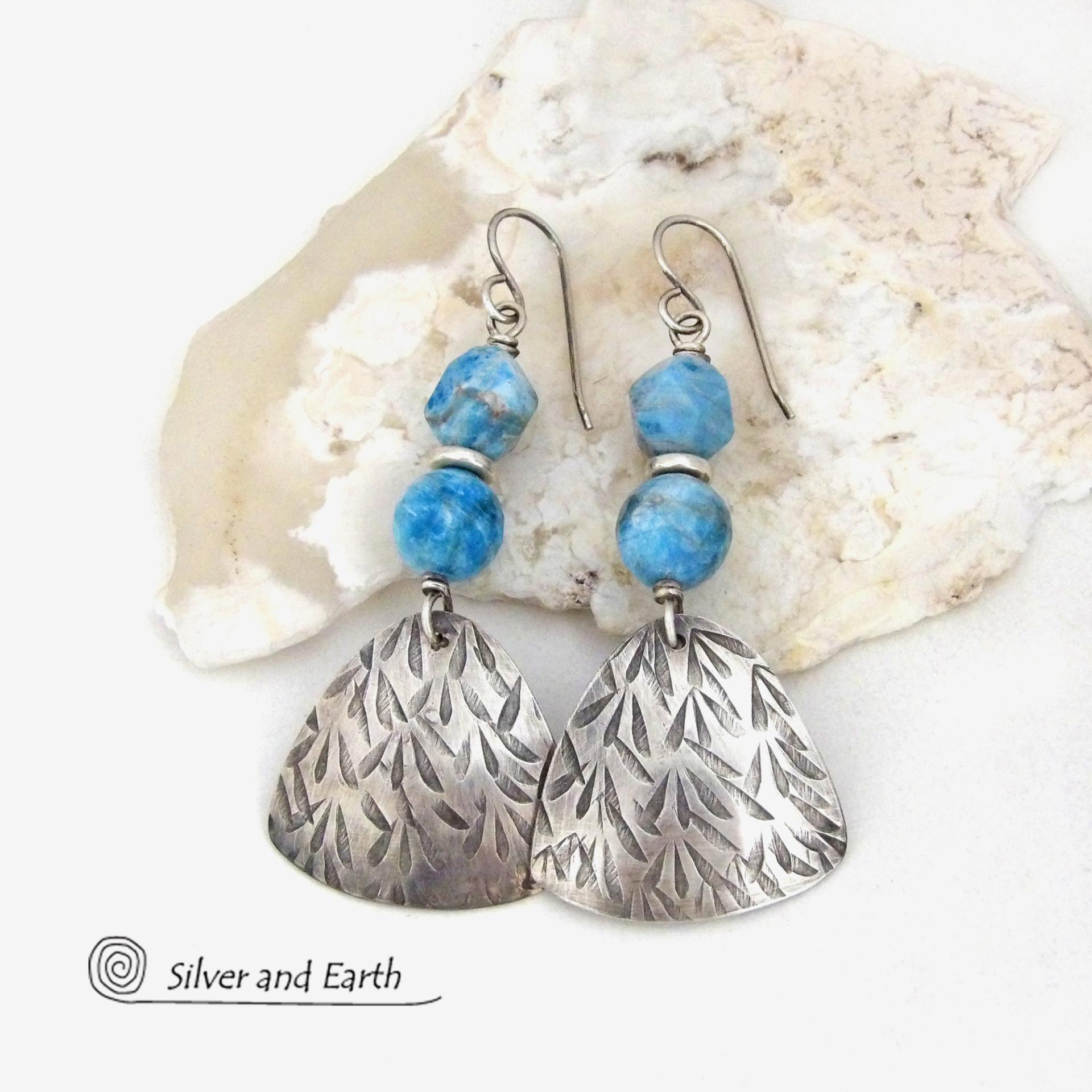 These handcrafted sterling silver dangle earrings have a hand stamped texture and are accented with natural apatite gemstones. The stones have a beautiful blue hue and the ones on top have a faceted nugget finish. They have an elegant, modern style that looks great with all wardrobe styles - dressed up or down.
