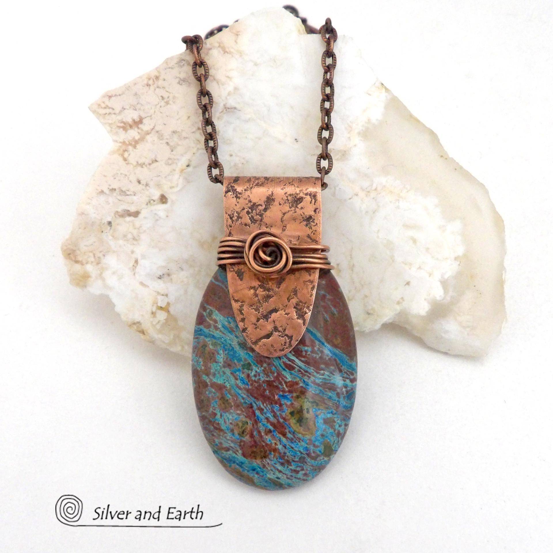 This pendant necklace features a beautiful aqua jasper gemstone with stunning hues of blue and brown accented with a hand forged copper bail with a lightly hammered texture. It's accented with twists of solid copper wire which forms a spiral in front. Unique and one-of-a-kind, it makes a great gift for a natural stone lover - or a nice addition to your own jewelry collection.