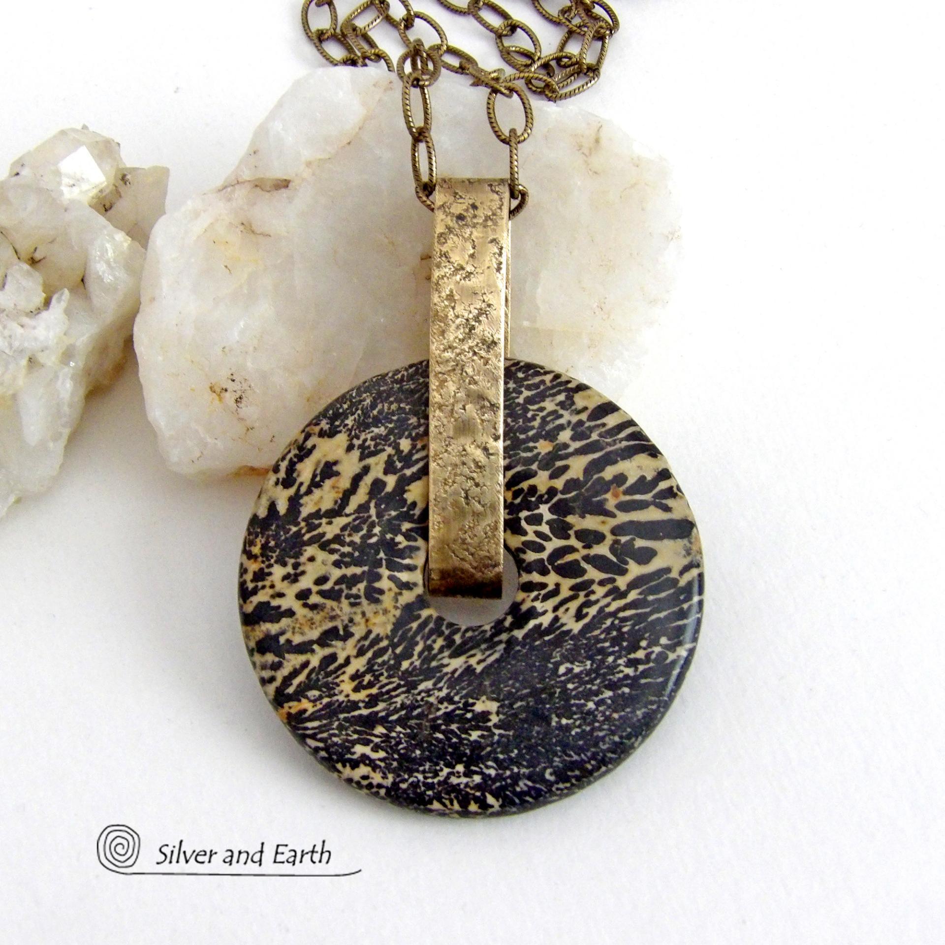 This one-of-a-kind pendant necklace features a stunning artistic jasper stone accented with a hand forged gold brass bail. This type of jasper is known for its intricate, natural patterns that resemble brushstrokes, landscapes, or abstract art. The stone in this piece has a natural bold dramatic pattern in hues of black and soft golden yellow with black streaks that resemble "feathery" dendrites. The design is modern and bold - yet classic and always in fashion. It can be worn by either a man or women. 