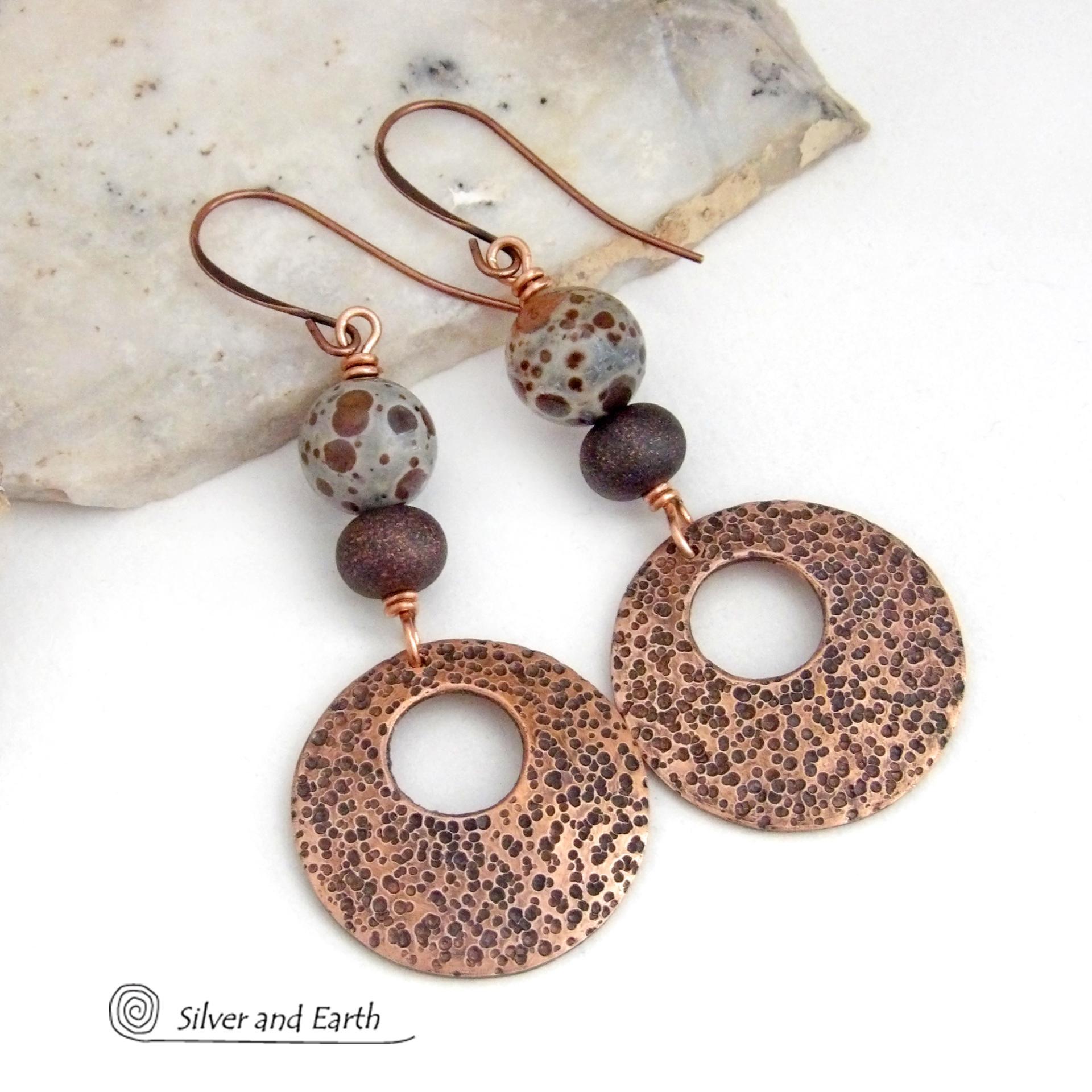 These handcrafted earrings feature round copper hoop dangles with a rustic hand stamped texture accented with natural spotted asteroid jasper and bronze glass beads. Unique and striking, they have an earthy organic flair that makes a bold statement. The jasper stones have a great natural spotted pattern with earthy shades of chocolate brown and grey. Your choice of ear wires - copper or hypoallergenic niobium.