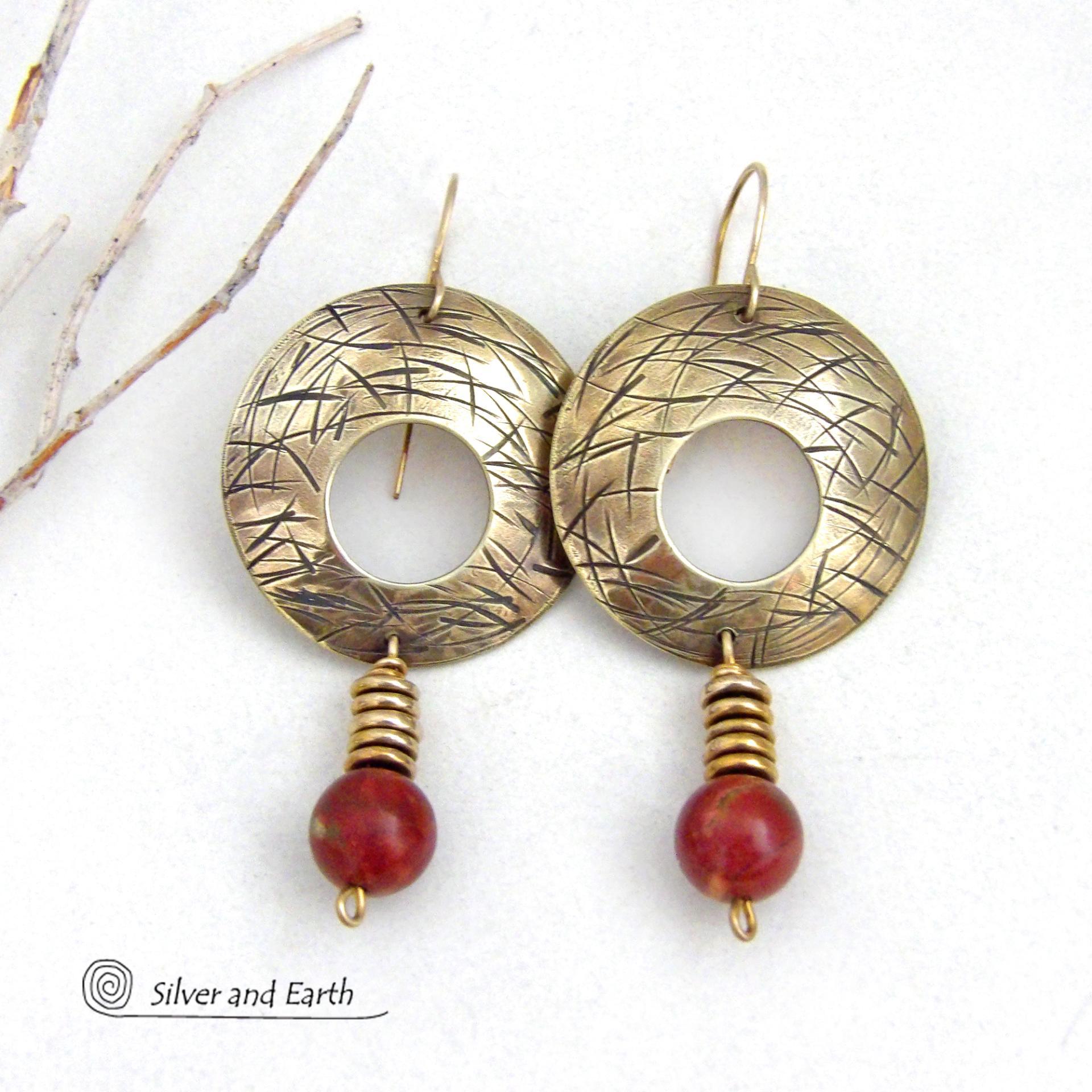 These handcrafted gold brass earrings have a hand stamped texture and are accented with dangling burgundy jasper gemstones and brass beads. Big and bold, they have a modern chic vibe that makes a striking eye-catching statement. Handmade in the USA by Silver and Earth Jewelry. 