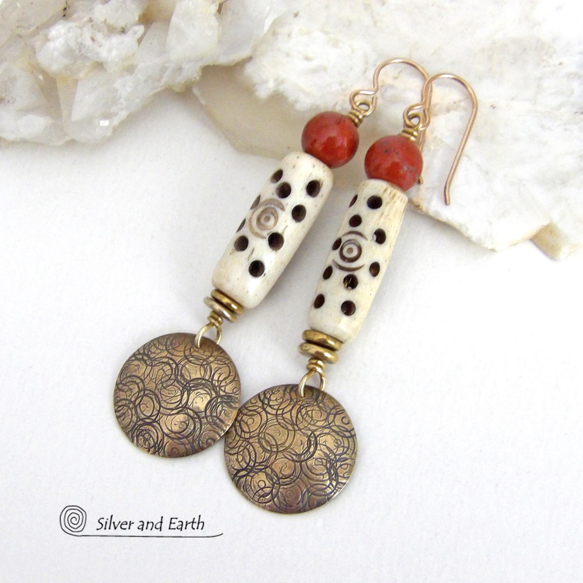 These handcrafted earrings feature a carved African bone beads, red jasper gemstones and textured gold brass dangles. Unique and striking, they have a boho chic style with lots of tribal flair. Perfect for women that love to wear bold unique artisan handmade jewelry. Handmade in the USA by Silver and Earth Jewelry. 