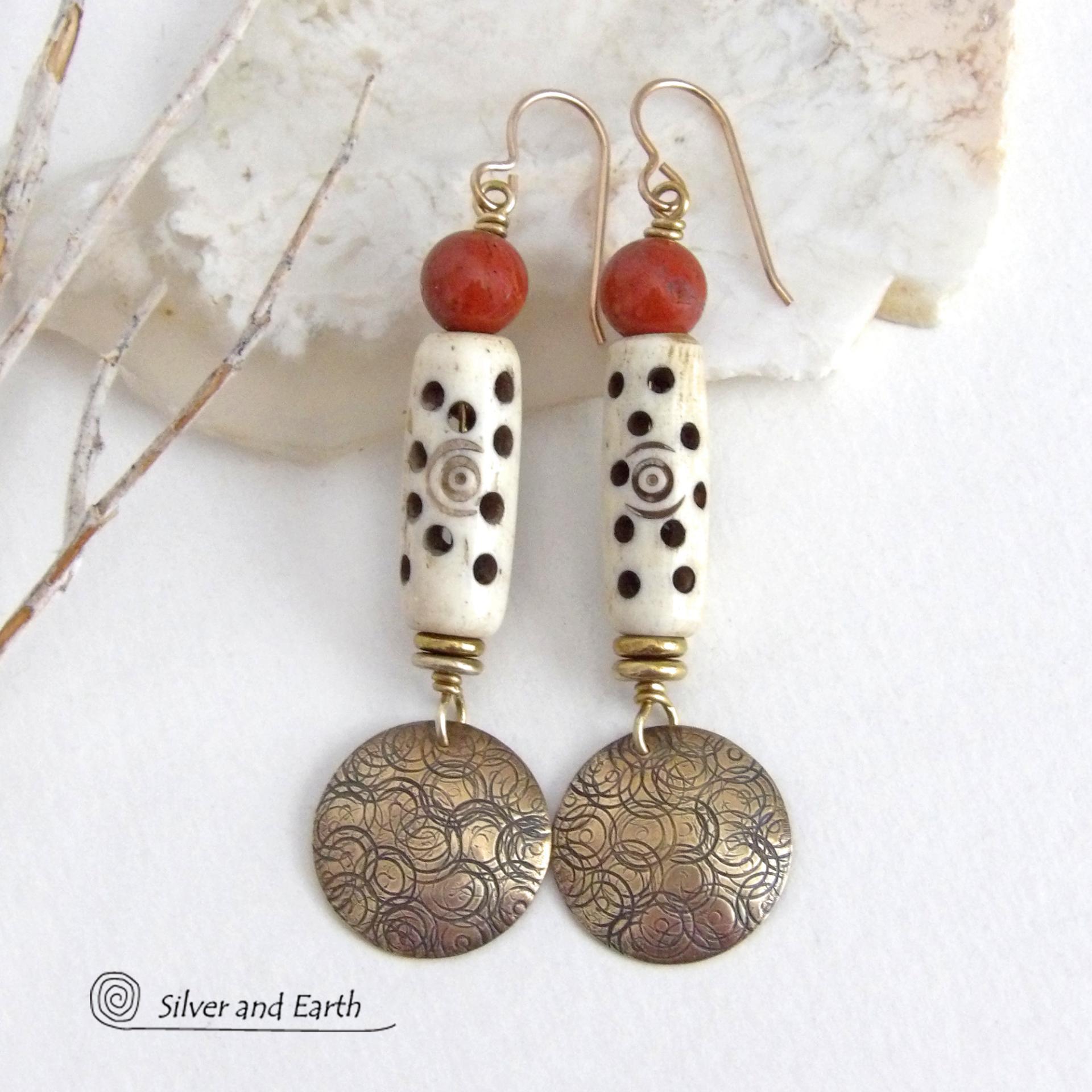 These handcrafted earrings feature a carved African bone beads, red jasper gemstones and textured gold brass dangles. Unique and striking, they have a boho chic style with lots of tribal flair. Perfect for women that love to wear bold unique artisan handmade jewelry. Handmade in the USA by Silver and Earth Jewelry. 