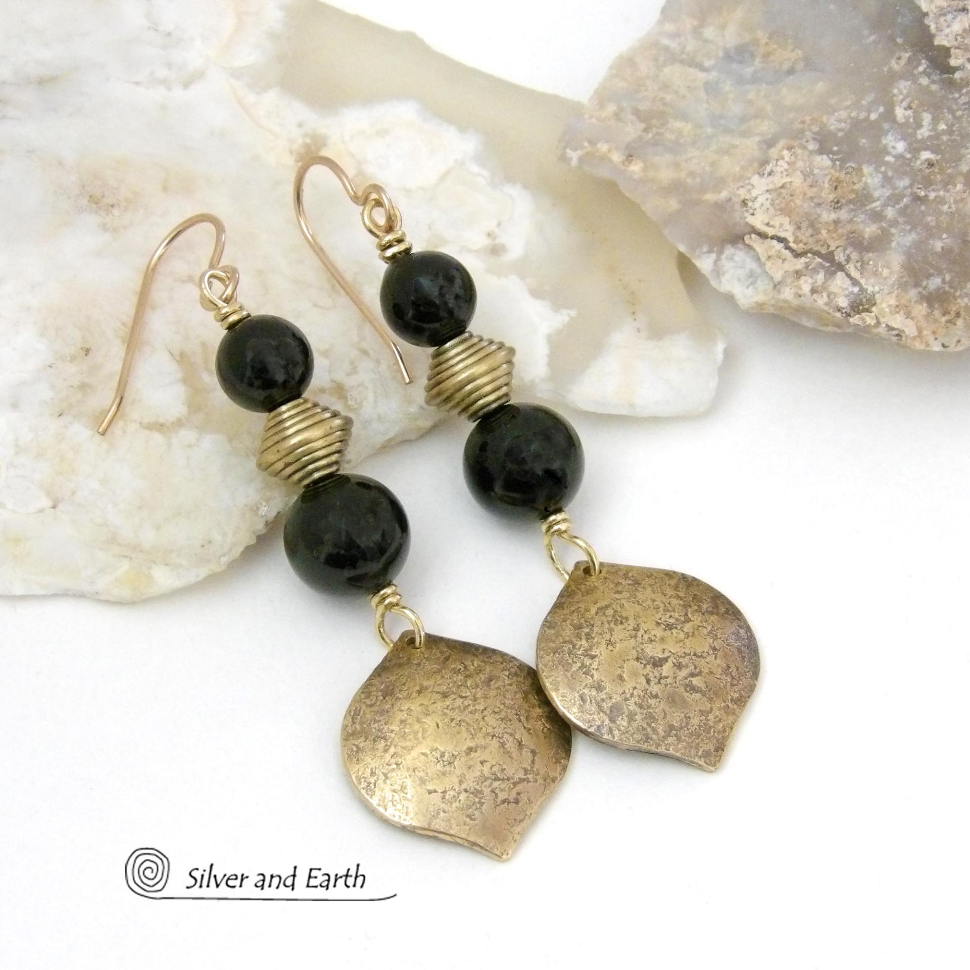 These handcrafted earrings feature gold brass dangles with a hammered raw silk texture accented with black onyx gemstones and brass beads. They have a modern boho chic style with a touch of Egyptian inspired flair that coordinates beautifully with all wardrobe types. Perfect for women that love artisan handcrafted jewelry that makes a bold statement. Handmade in the USA by Silver and Earth Jewelry. 
