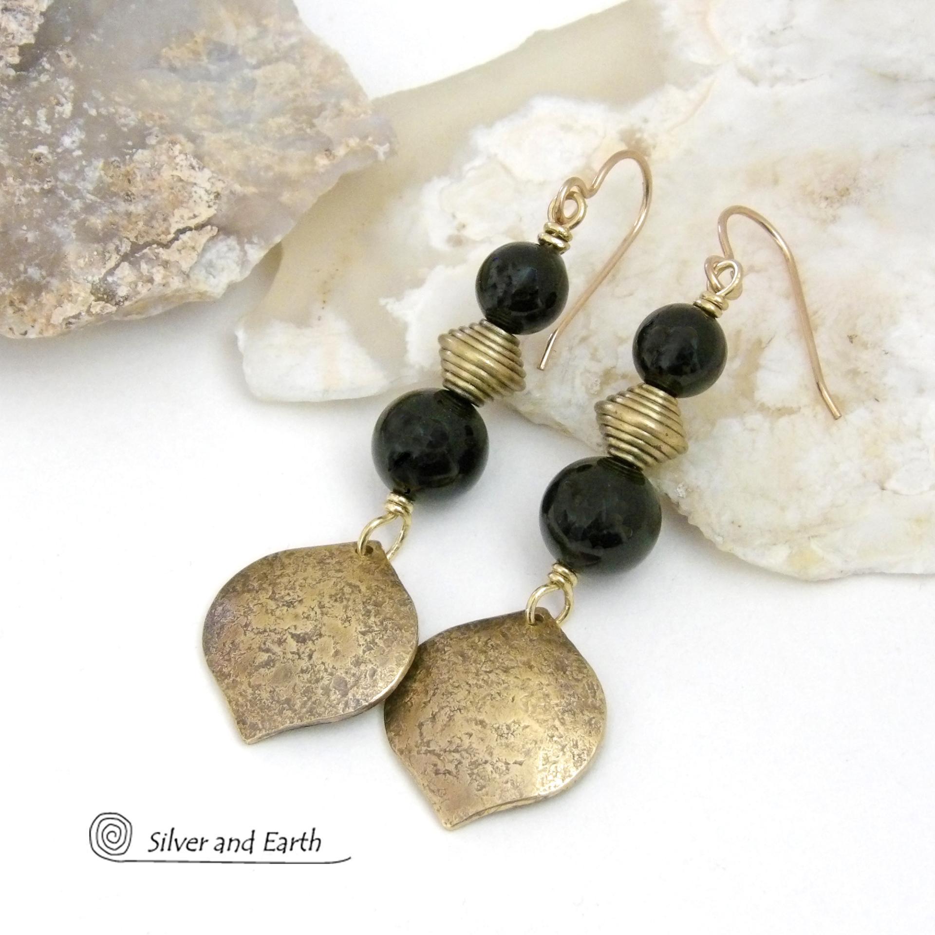 These handcrafted earrings feature gold brass dangles with a hammered raw silk texture accented with black onyx gemstones and brass beads. They have a modern boho chic style with a touch of Egyptian inspired flair that coordinates beautifully with all wardrobe types. Perfect for women that love artisan handcrafted jewelry that makes a bold statement. Handmade in the USA by Silver and Earth Jewelry. 