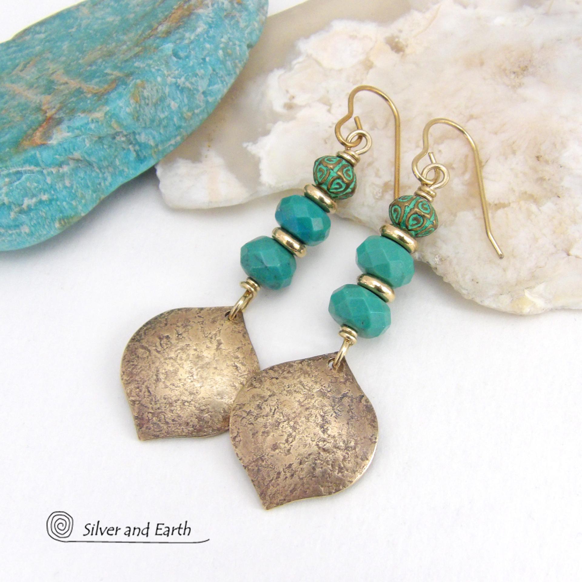 These handcrafted earrings feature gold brass dangles with a hammered organic silky texture accented with faceted genuine turquoise gemstones, tiny brass beads and blue-green patina beads with a tribal style pattern. They have an elegant modern style with a boho chic flair and will make a unique statement. Handmade in the USA by Silver and Earth Jewelry. 