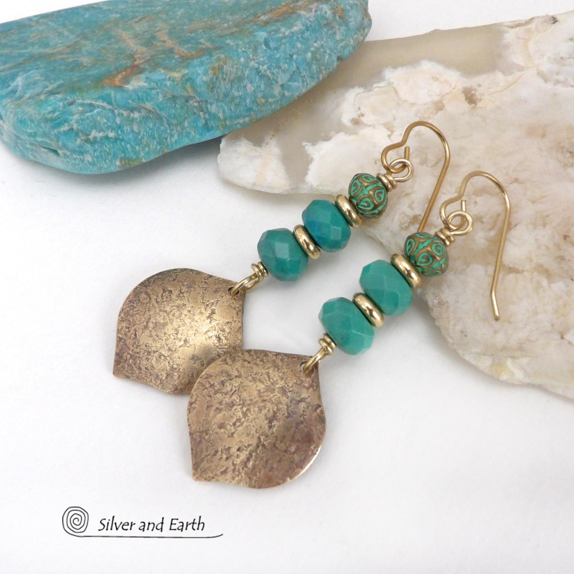 These handcrafted earrings feature gold brass dangles with a hammered organic silky texture accented with faceted genuine turquoise gemstones, tiny brass beads and blue-green patina beads with a tribal style pattern. They have an elegant modern style with a boho chic flair and will make a unique statement. Handmade in the USA by Silver and Earth Jewelry. 