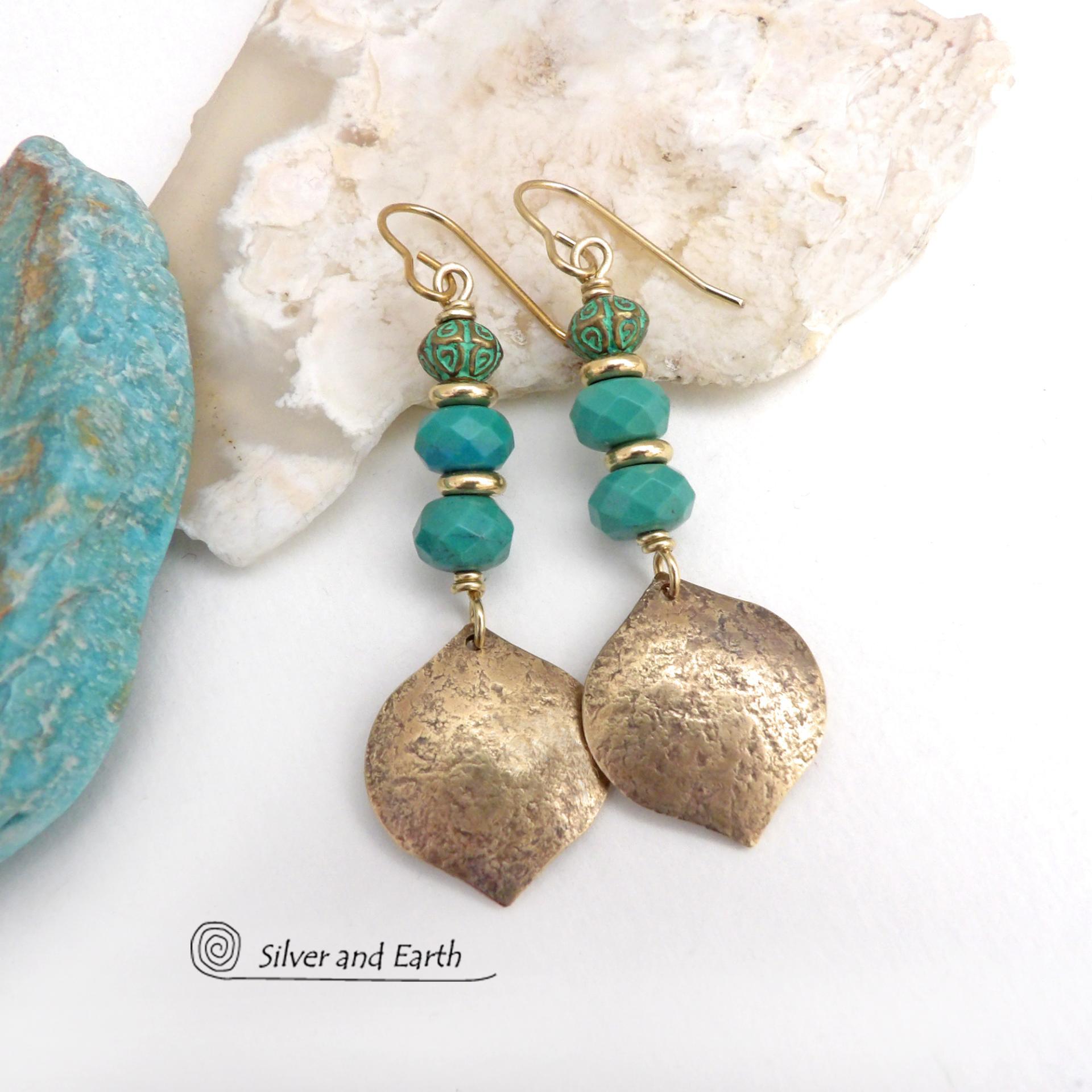 These handcrafted earrings feature gold brass dangles with a hammered organic silky texture accented with faceted genuine turquoise gemstones, tiny brass beads and blue-green patina beads with a tribal style pattern. They have an elegant modern style with a boho chic flair and will make a unique statement. Handmade in the USA by Silver and Earth Jewelry. 