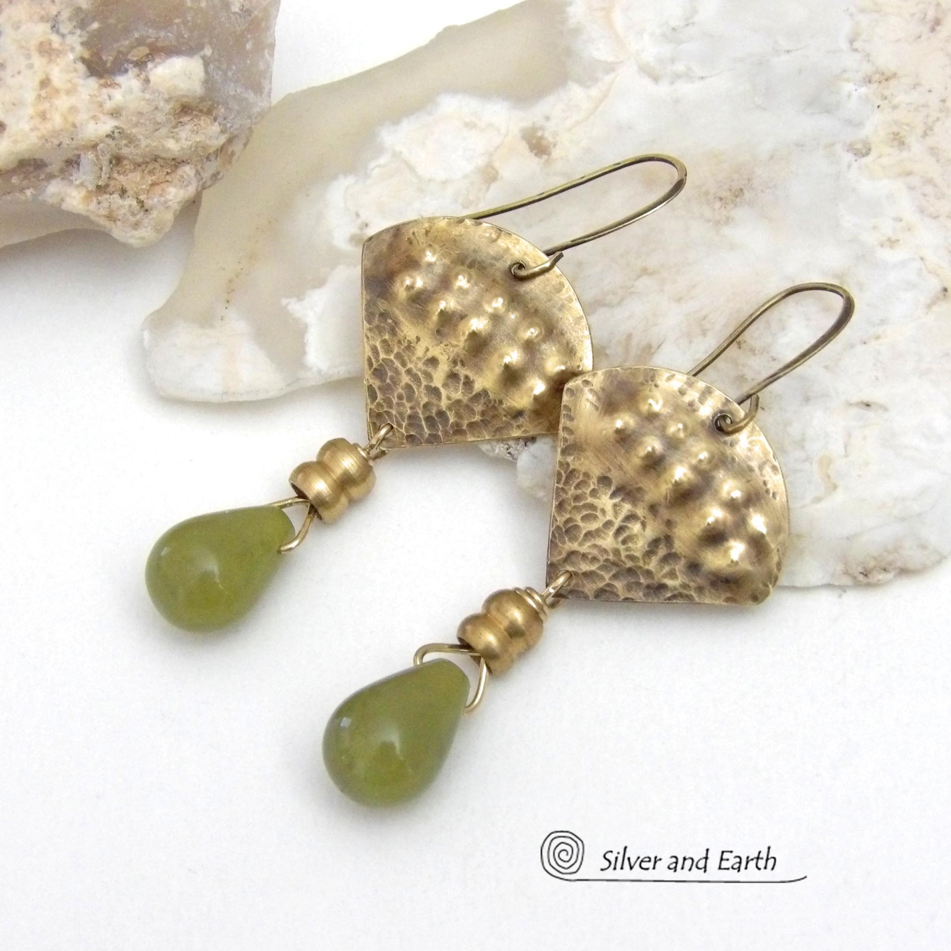 Bold and unique, these handcrafted earrings have an exotic bohemian style with a touch of Egyptian flair. They feature gold brass with a hammered and stamped texture accented with teardrop-shaped natural green jade gemstones and brass beads. Perfect for women that love to wear unique artisan handcrafted jewelry. Total length of approximately 2-3/8" from top of brass ear wires and 1" at widest point. Handmade in the USA by Silver and Earth Jewelry. 