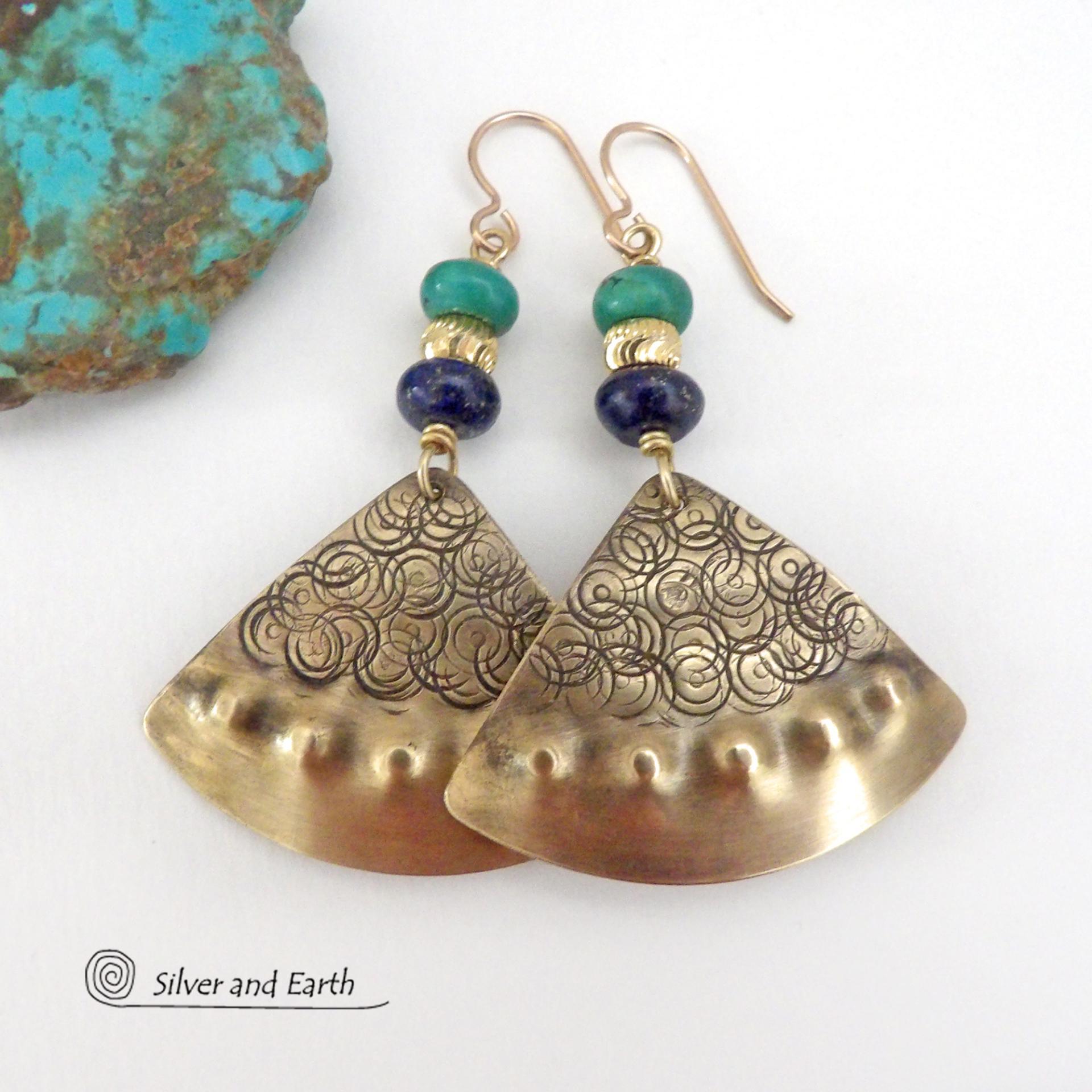 These handcrafted gold brass earrings have an exotic, Egyptian inspired vibe. The design consists of brass fan-shaped dangles with a hand textured design accented with lapis lazuli and turquoise gemstones and gold plated beads. Bold and unique, they'll add a touch of cultural exotic charm to any type of wardrobe. Handmade in the USA by Silver and Earth Jewelry. 