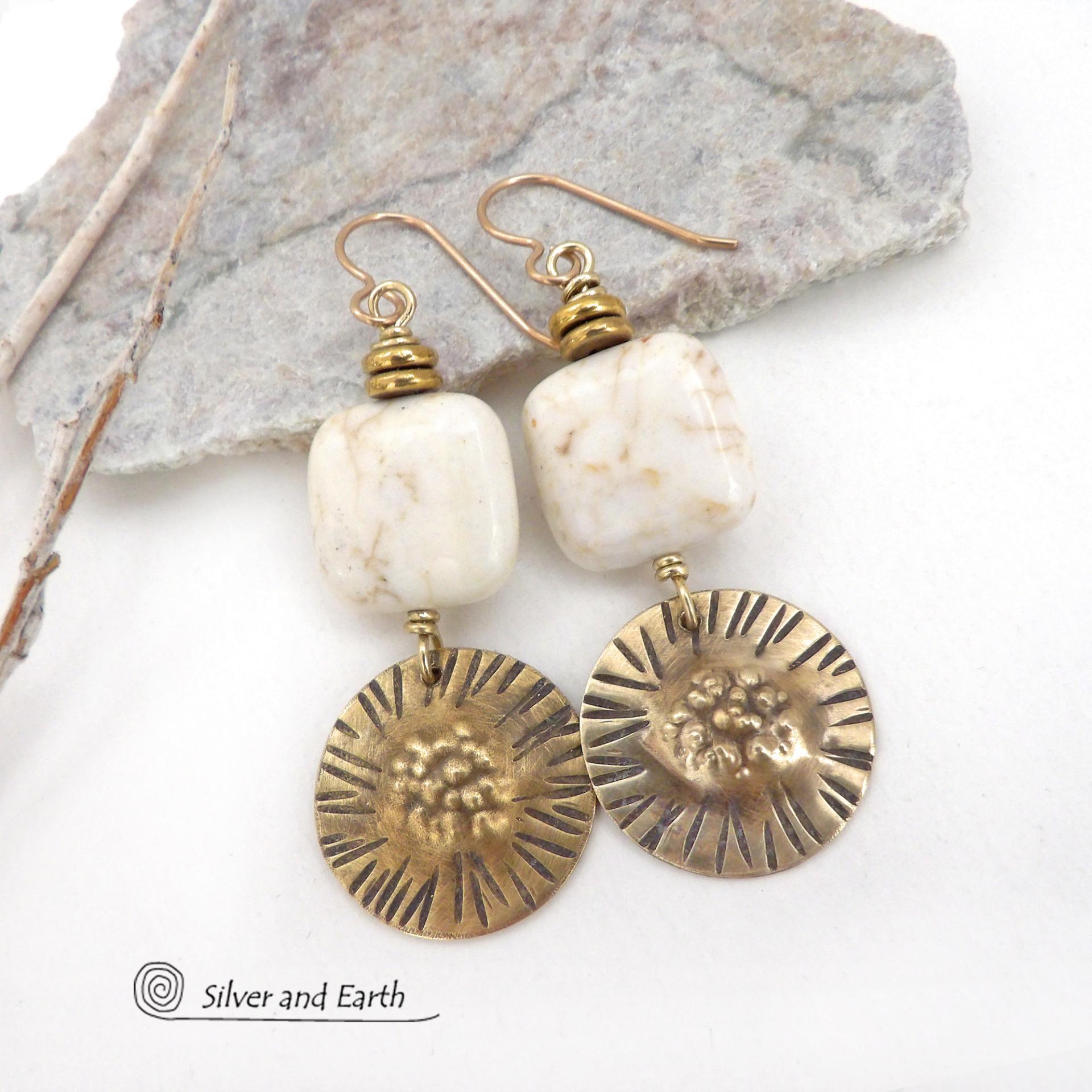 These gold brass dangle earrings have a unique hand textured design and are accented with creamy white magnesite stones. The stones have a natural matrix of golden-brown speckled inclusions and are topped off with tiny brass beads. I created the dangles out of solid gold brass sheet; and then created the texture which reminds me of the golden rays of the sun. The metal was oxidized to enhance the detail; then sealed with jeweler's wax to resist tarnishing. Handmade in the USA by Silver and Earth Jewelry.