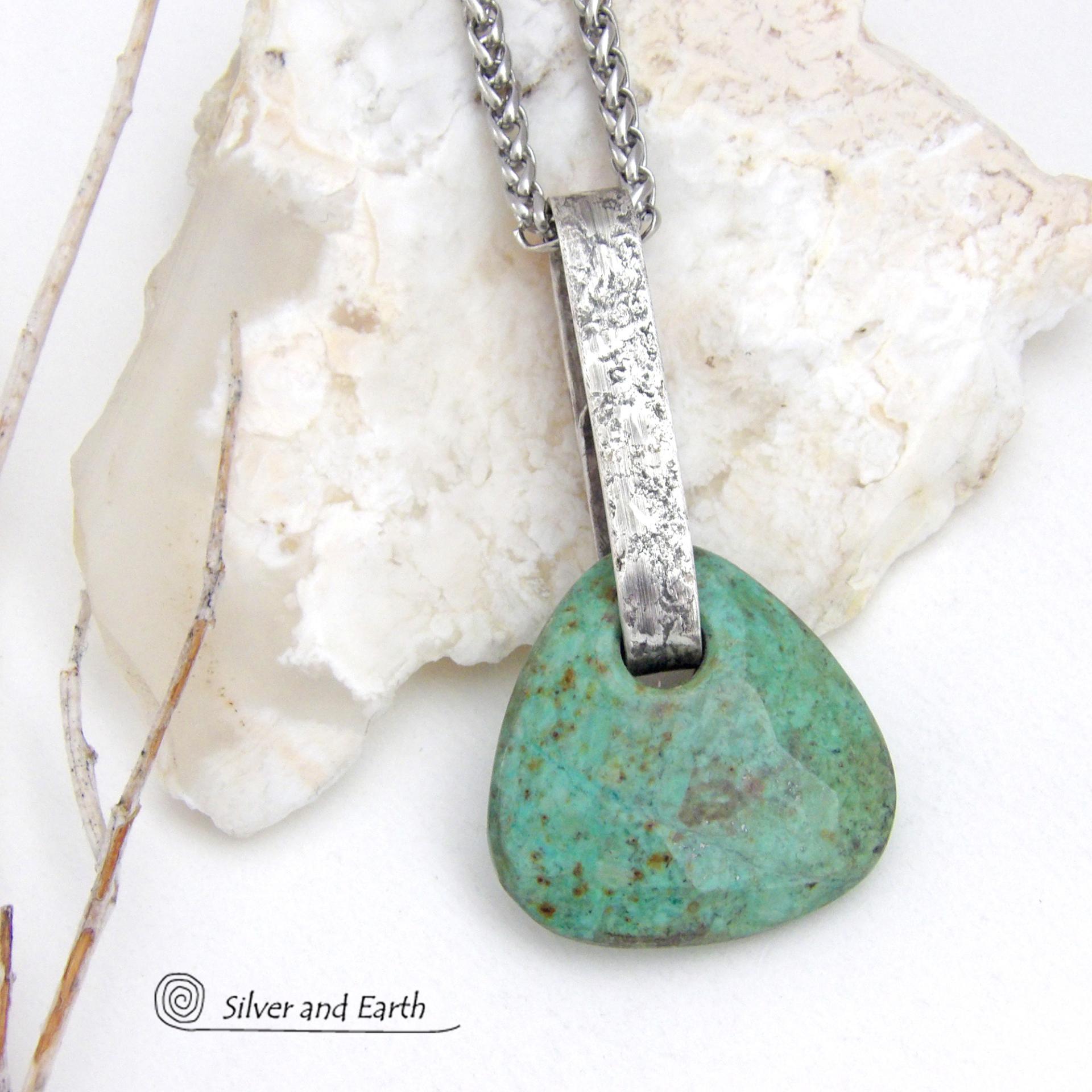 This one-of-a-kind pendant necklace features a beautiful chunky natural chrysocolla gemstone with a faceted finish. The stone is a beautiful shade of bluish-green which resembles turquoise. It hangs from a hand forged solid sterling silver bail with a lightly hammered organic texture. It's reversible. Unique and one-of-a-kind, it's sure to make a statement. Handmade in the USA by Silver and Earth Jewelry.