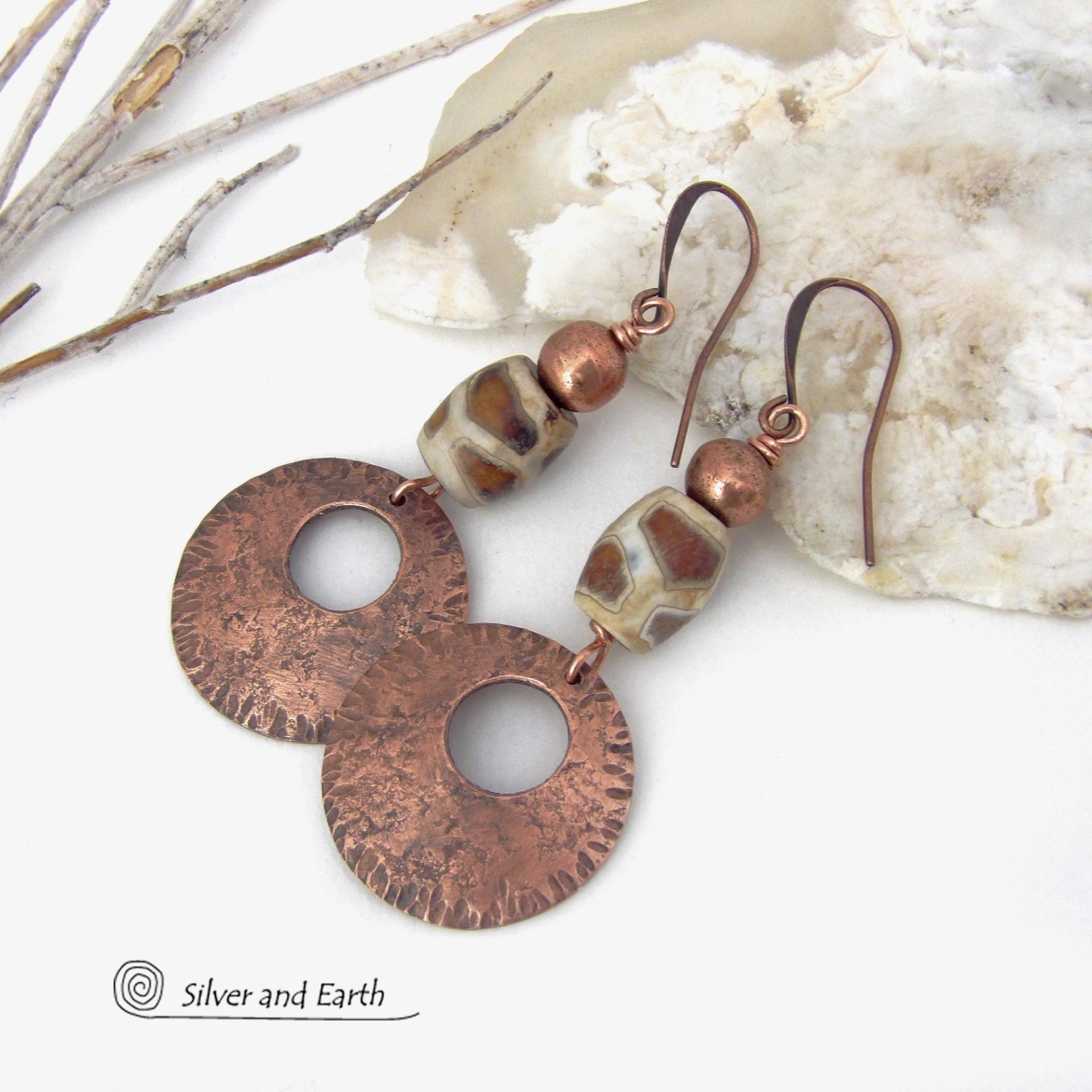 These handcrafted copper earrings have a bold, ethnic African style and flair. They feature round copper dangles with a rustic hammered texture accented with African etched giraffe print agate stones topped off with solid copper beads. Unique and striking, they'll make a bold statement. Perfect for women that love ethnic tribal style jewelry. Handmade in the USA by Silver and Earth Jewelry. 