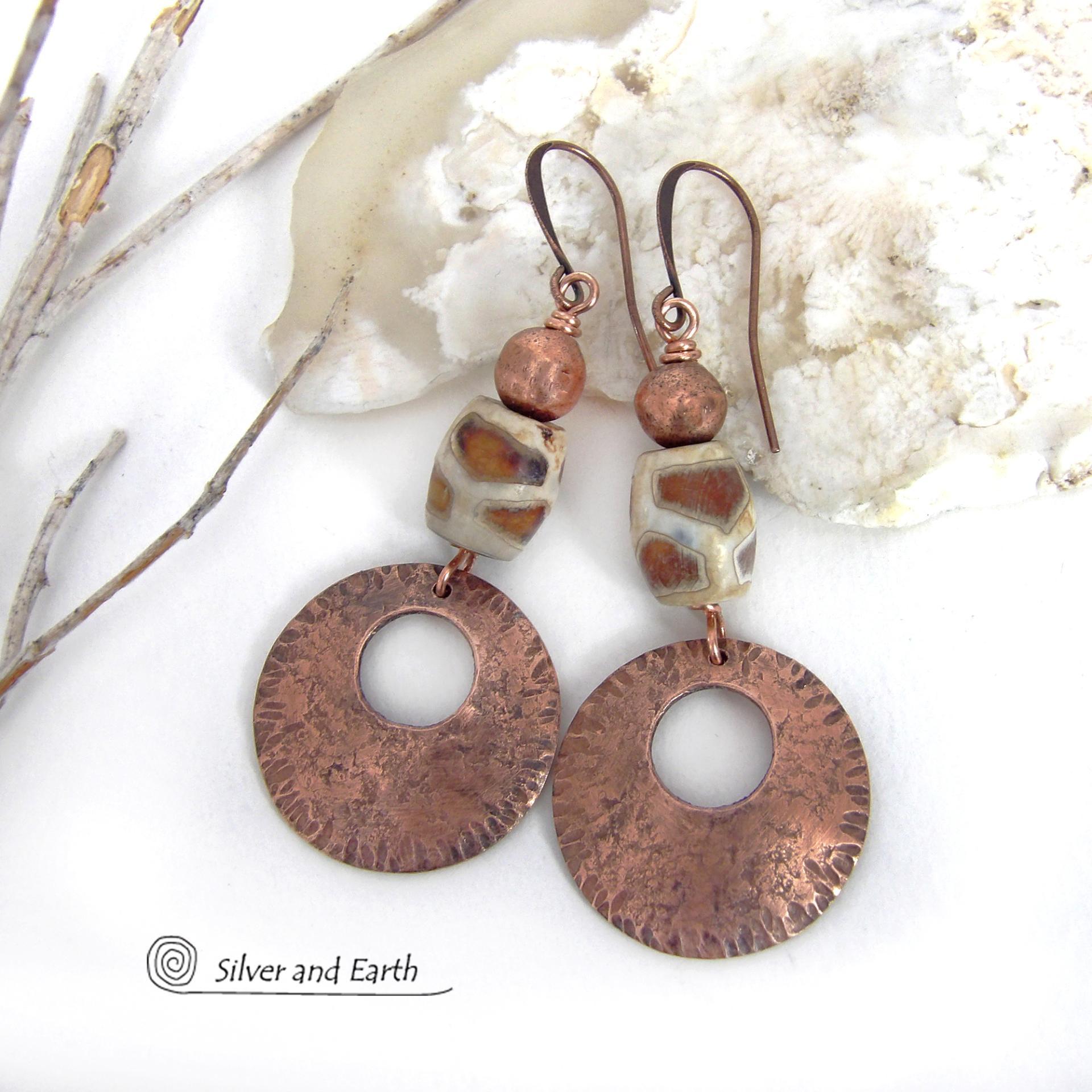 These handcrafted copper earrings have a bold, ethnic African style and flair. They feature round copper dangles with a rustic hammered texture accented with African etched giraffe print agate stones topped off with solid copper beads. Unique and striking, they'll make a bold statement. Perfect for women that love ethnic tribal style jewelry. Handmade in the USA by Silver and Earth Jewelry. 