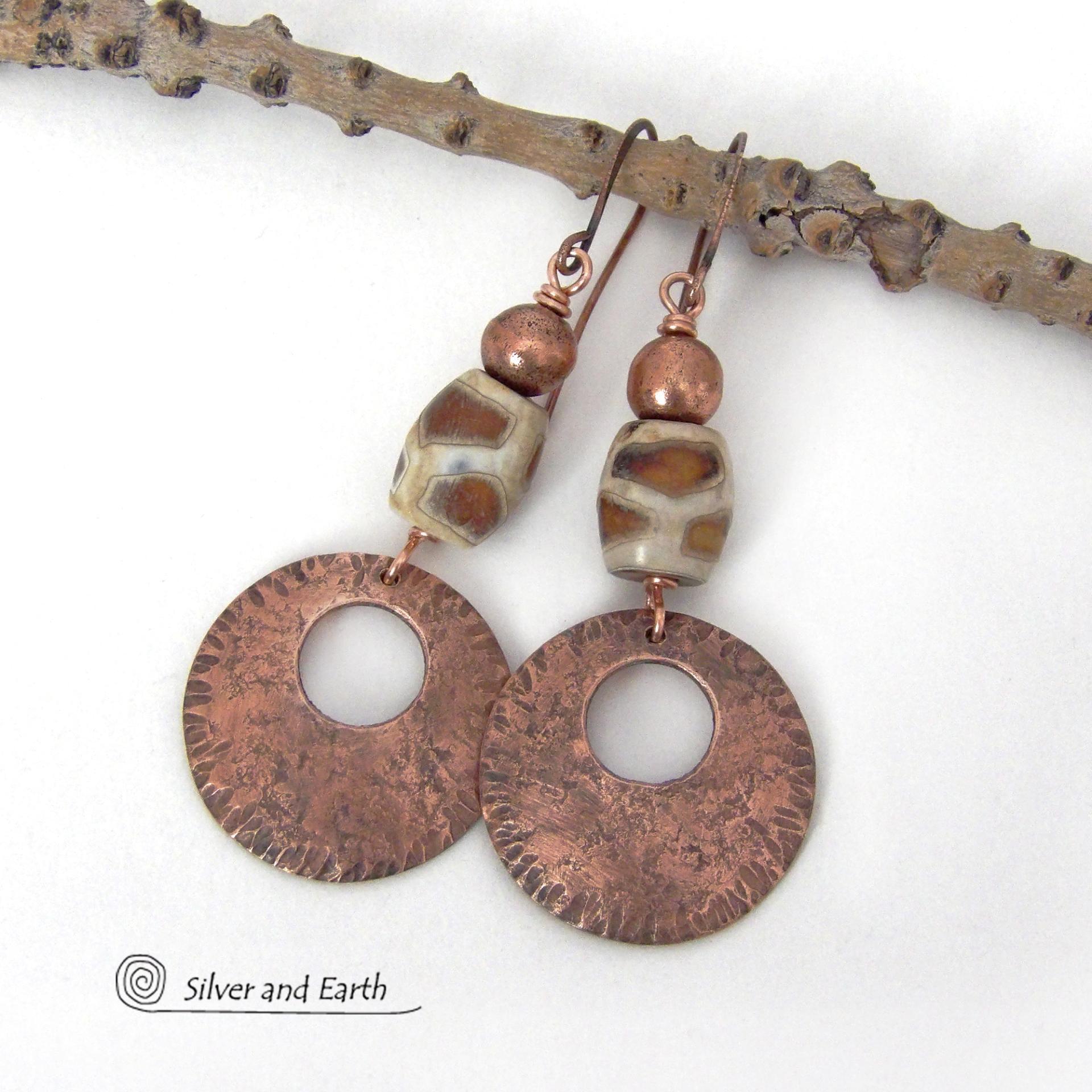 These handcrafted copper earrings have a bold, ethnic African style and flair. They feature round copper dangles with a rustic hammered texture accented with African etched giraffe print agate stones topped off with solid copper beads. Unique and striking, they'll make a bold statement. Perfect for women that love ethnic tribal style jewelry. Handmade in the USA by Silver and Earth Jewelry. 