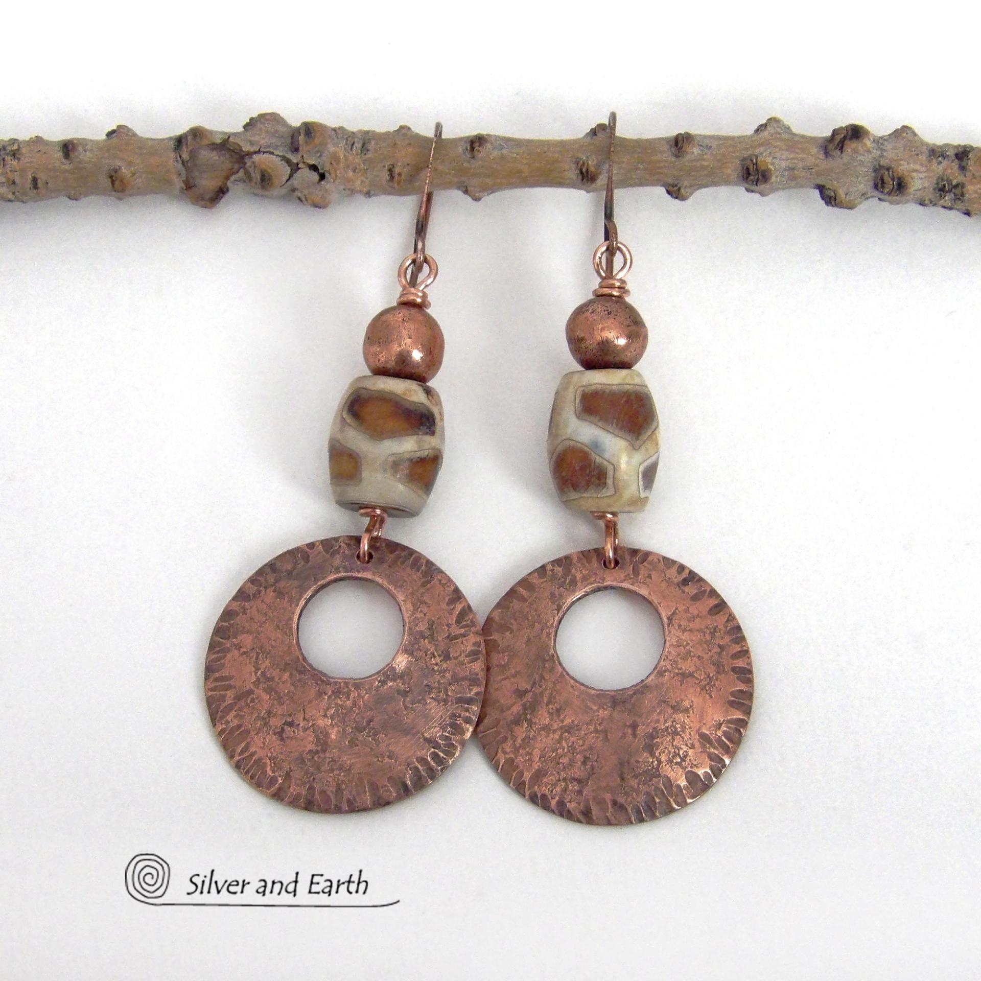 These handcrafted copper earrings have a bold, ethnic African style and flair. They feature round copper dangles with a rustic hammered texture accented with African etched giraffe print agate stones topped off with solid copper beads. Unique and striking, they'll make a bold statement. Perfect for women that love ethnic tribal style jewelry. Handmade in the USA by Silver and Earth Jewelry. 