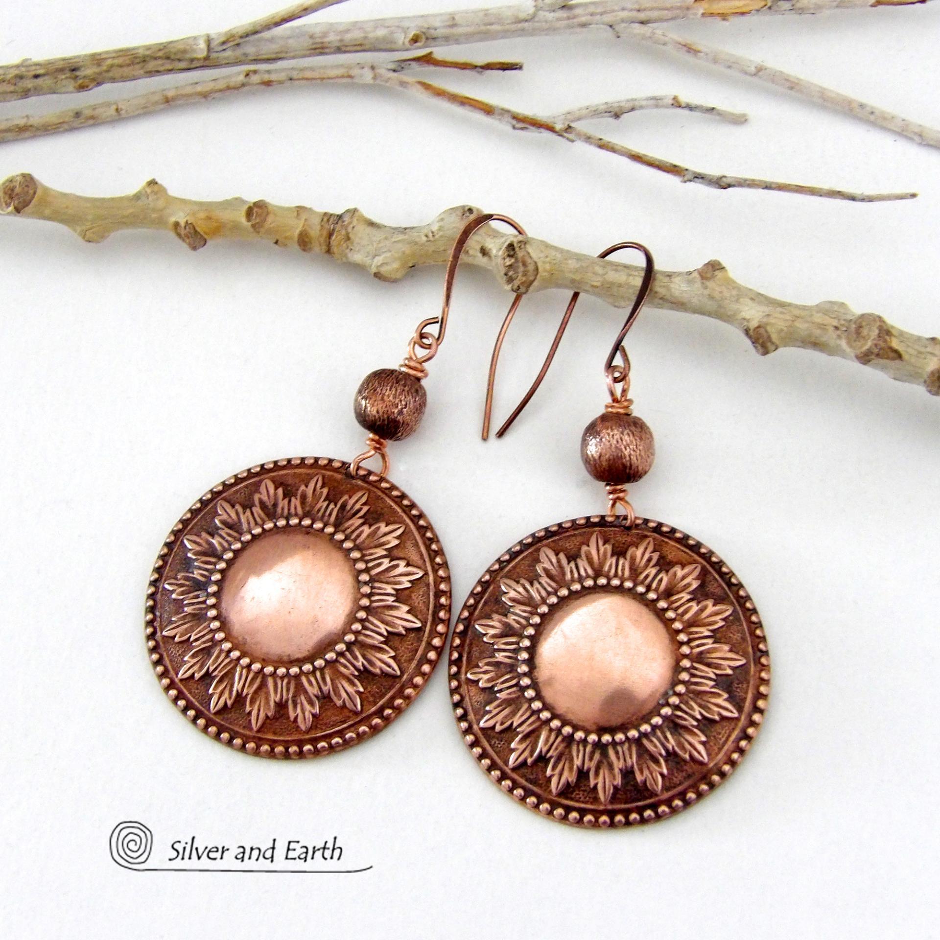 These handcrafted copper earrings have a beautifully detailed embossed sun medallion texture with an oxidized finish and are accented with brushed satin copper beads. Big and bold, they'll make a striking statement. Unique and versatile, they are lightweight and comfortable to wear and will look great with all wardrobe styles. Handmade in the USA by Silver and Earth Jewelry.