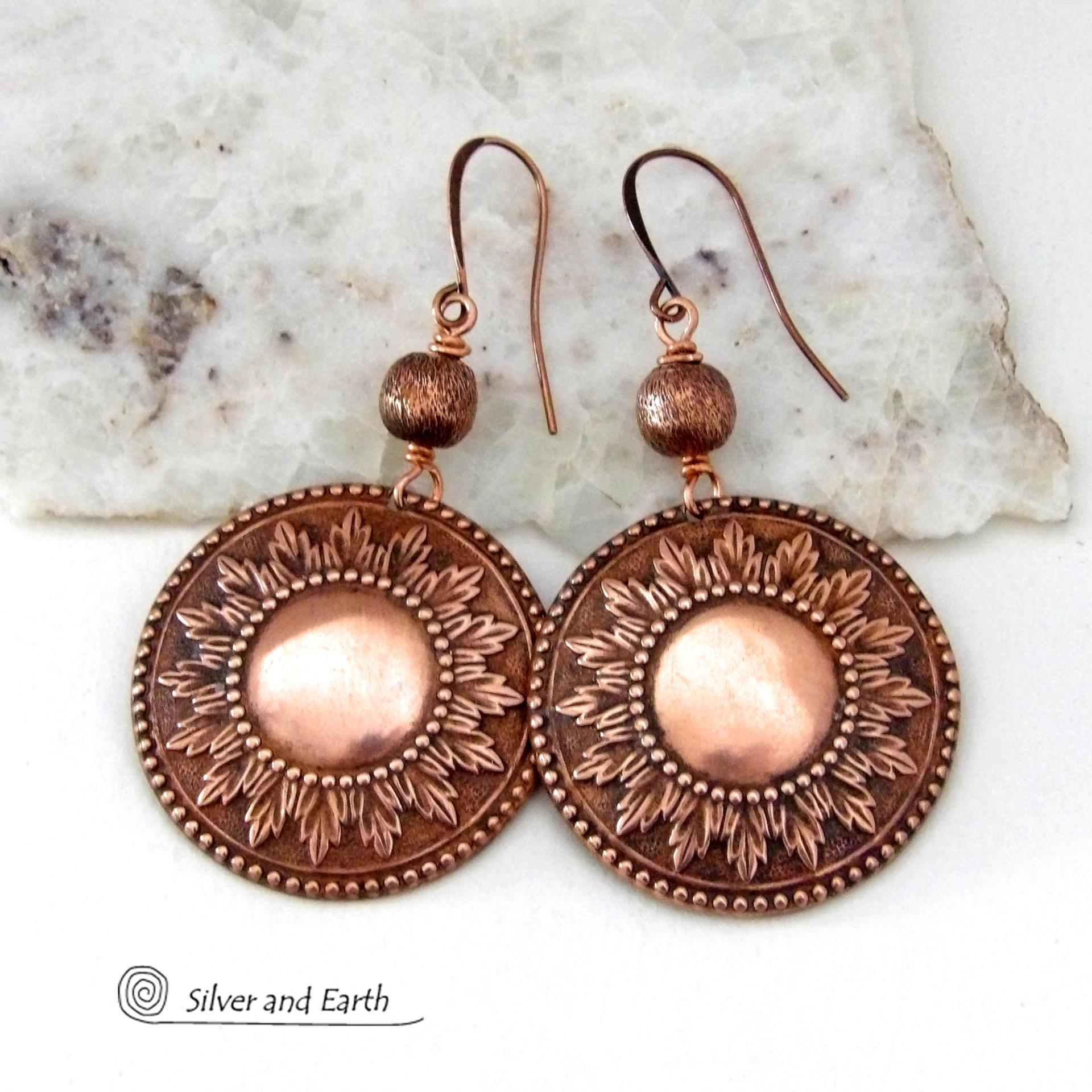These handcrafted copper earrings have a beautifully detailed embossed sun medallion texture with an oxidized finish and are accented with brushed satin copper beads. Big and bold, they'll make a striking statement. Unique and versatile, they are lightweight and comfortable to wear and will look great with all wardrobe styles. Handmade in the USA by Silver and Earth Jewelry.