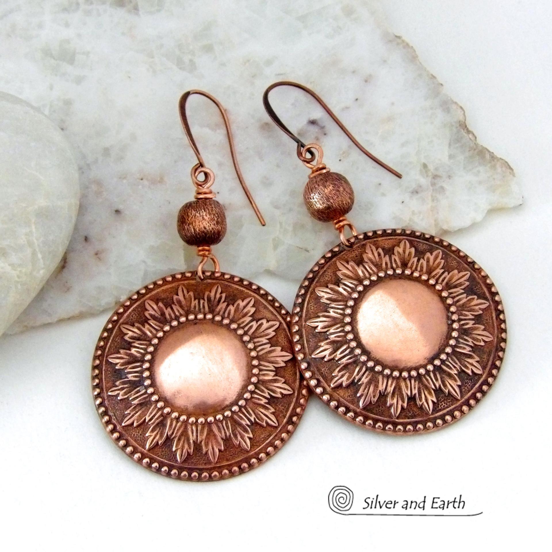 These handcrafted copper earrings have a beautifully detailed embossed sun medallion texture with an oxidized finish and are accented with brushed satin copper beads. Big and bold, they'll make a striking statement. Unique and versatile, they are lightweight and comfortable to wear and will look great with all wardrobe styles. Handmade in the USA by Silver and Earth Jewelry.